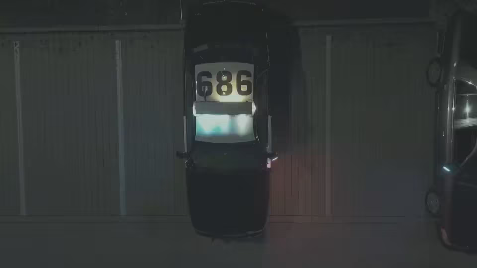 A police car seen from above at night, in Log footage that looks flat and gray